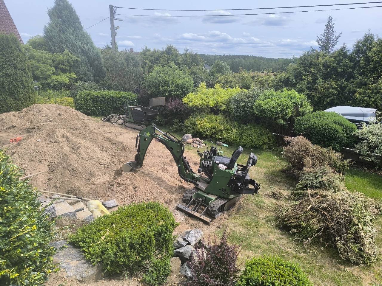 Bagr a dumper při terénních úpravách zahrady